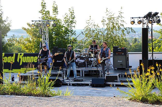 Die Bilder zeigen Eindrücke der Rock-Nacht am Eckert Beach. Zu sehen sind die Live-Auftritte der Bands Rusty Road Runners und ACBarbingCity´25, zahlreiche Besucherinnen und Besucher vor der Bühne sowie die sommerliche Atmosphäre am Strand. In beiden Bands stehen auch Dozenten der Eckert Schulen auf der Bühne. Die Aufnahmen zeigen Musiker, Publikum und die stimmungsvolle Beleuchtung während des Open-Air-Konzerts.