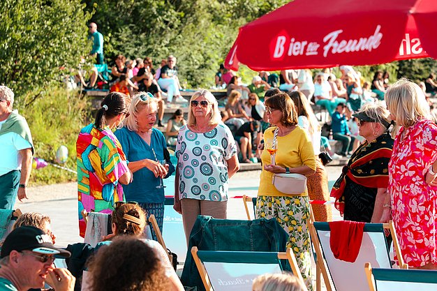 Gäste genießen gemeinsam die ausgelassene Atmosphäre bei der 80er-Jahre-Party am Eckert Beach.