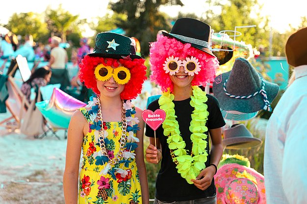 Gäste genießen gemeinsam die ausgelassene Atmosphäre bei der 80er-Jahre-Party am Eckert Beach.