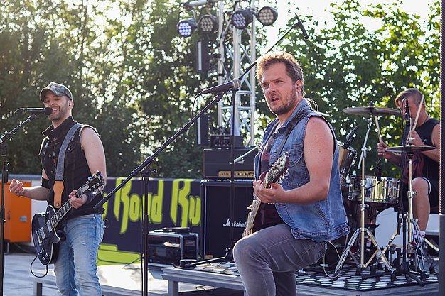 Die Bilder zeigen Eindrücke der Rock-Nacht am Eckert Beach. Zu sehen sind die Live-Auftritte der Bands Rusty Road Runners und ACBarbingCity´25, zahlreiche Besucherinnen und Besucher vor der Bühne sowie die sommerliche Atmosphäre am Strand. In beiden Bands stehen auch Dozenten der Eckert Schulen auf der Bühne. Die Aufnahmen zeigen Musiker, Publikum und die stimmungsvolle Beleuchtung während des Open-Air-Konzerts.