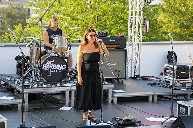 Die Bilder zeigen Eindrücke der Rock-Nacht am Eckert Beach. Zu sehen sind die Live-Auftritte der Bands Rusty Road Runners und ACBarbingCity´25, zahlreiche Besucherinnen und Besucher vor der Bühne sowie die sommerliche Atmosphäre am Strand. In beiden Bands stehen auch Dozenten der Eckert Schulen auf der Bühne. Die Aufnahmen zeigen Musiker, Publikum und die stimmungsvolle Beleuchtung während des Open-Air-Konzerts.