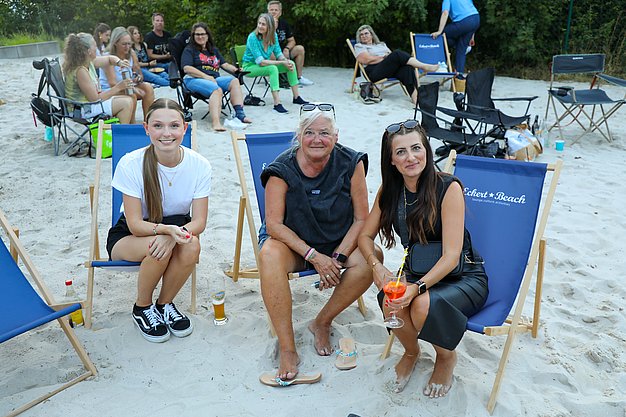 Die Bilder zeigen Eindrücke der Rock-Nacht am Eckert Beach. Zu sehen sind die Live-Auftritte der Bands Rusty Road Runners und ACBarbingCity´25, zahlreiche Besucherinnen und Besucher vor der Bühne sowie die sommerliche Atmosphäre am Strand. In beiden Bands stehen auch Dozenten der Eckert Schulen auf der Bühne. Die Aufnahmen zeigen Musiker, Publikum und die stimmungsvolle Beleuchtung während des Open-Air-Konzerts.