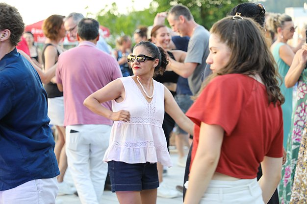 Die Diashow zeigt Eindrücke vom Salsa-Abend am Eckert Beach. Zu sehen sind tanzende Paare, Besucherinnen und Besucher im Publikum sowie die stimmungsvolle Atmosphäre der Veranstaltung am Abend.