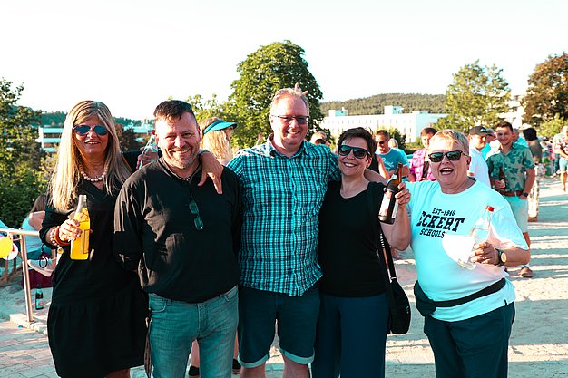 Gäste genießen gemeinsam die ausgelassene Atmosphäre bei der 80er-Jahre-Party am Eckert Beach.