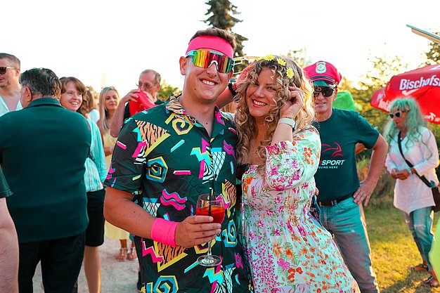 Gäste genießen gemeinsam die ausgelassene Atmosphäre bei der 80er-Jahre-Party am Eckert Beach.