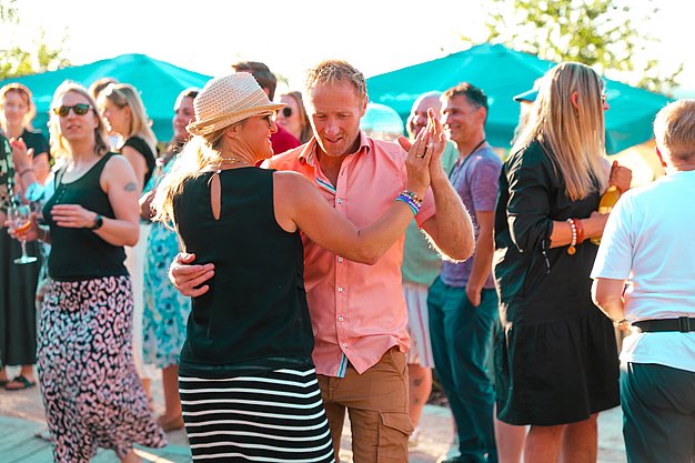 Gäste genießen gemeinsam die ausgelassene Atmosphäre bei der 80er-Jahre-Party am Eckert Beach.