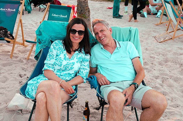 Gäste genießen gemeinsam die ausgelassene Atmosphäre bei der 80er-Jahre-Party am Eckert Beach.