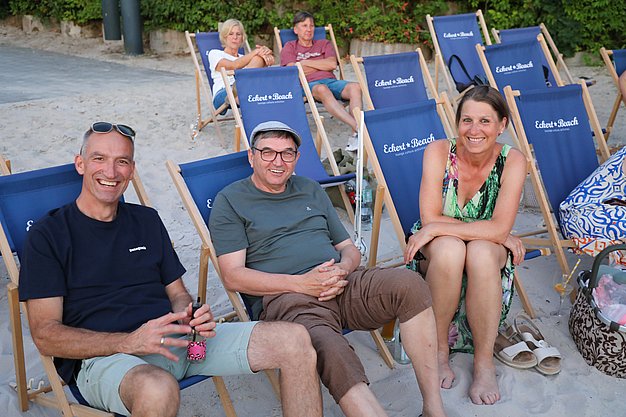 Die Diashow zeigt Eindrücke vom Salsa-Abend am Eckert Beach. Zu sehen sind tanzende Paare, Besucherinnen und Besucher im Publikum sowie die stimmungsvolle Atmosphäre der Veranstaltung am Abend.