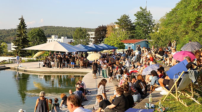 Die Bilder zeigen Eindrücke der Rock-Nacht am Eckert Beach. Zu sehen sind die Live-Auftritte der Bands Rusty Road Runners und ACBarbingCity´25, zahlreiche Besucherinnen und Besucher vor der Bühne sowie die sommerliche Atmosphäre am Strand. In beiden Bands stehen auch Dozenten der Eckert Schulen auf der Bühne. Die Aufnahmen zeigen Musiker, Publikum und die stimmungsvolle Beleuchtung während des Open-Air-Konzerts.