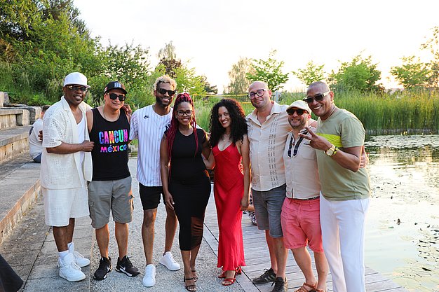 Die Diashow zeigt Eindrücke vom Salsa-Abend am Eckert Beach. Zu sehen sind tanzende Paare, Besucherinnen und Besucher im Publikum sowie die stimmungsvolle Atmosphäre der Veranstaltung am Abend.
