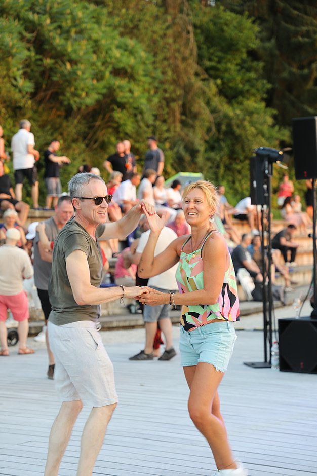 Die Diashow zeigt Eindrücke vom Salsa-Abend am Eckert Beach. Zu sehen sind tanzende Paare, Besucherinnen und Besucher im Publikum sowie die stimmungsvolle Atmosphäre der Veranstaltung am Abend.