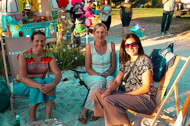 Gäste genießen gemeinsam die ausgelassene Atmosphäre bei der 80er-Jahre-Party am Eckert Beach.
