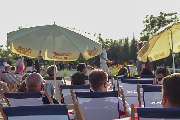 Die Bilder zeigen Eindrücke der Rock-Nacht am Eckert Beach. Zu sehen sind die Live-Auftritte der Bands Rusty Road Runners und ACBarbingCity´25, zahlreiche Besucherinnen und Besucher vor der Bühne sowie die sommerliche Atmosphäre am Strand. In beiden Bands stehen auch Dozenten der Eckert Schulen auf der Bühne. Die Aufnahmen zeigen Musiker, Publikum und die stimmungsvolle Beleuchtung während des Open-Air-Konzerts.