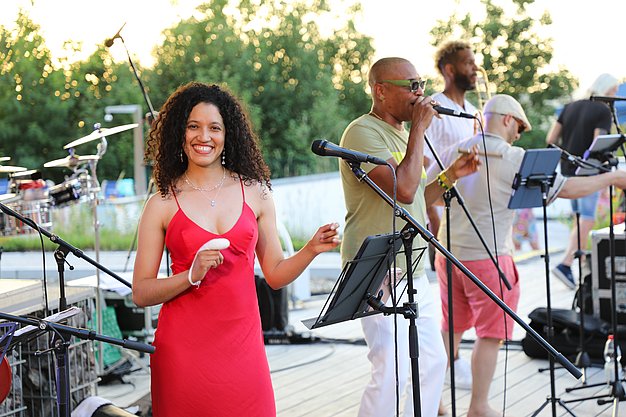 Die Diashow zeigt Eindrücke vom Salsa-Abend am Eckert Beach. Zu sehen sind tanzende Paare, Besucherinnen und Besucher im Publikum sowie die stimmungsvolle Atmosphäre der Veranstaltung am Abend.