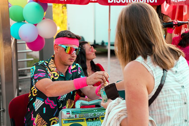 Gäste genießen gemeinsam die ausgelassene Atmosphäre bei der 80er-Jahre-Party am Eckert Beach.