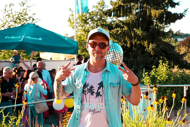 Gäste genießen gemeinsam die ausgelassene Atmosphäre bei der 80er-Jahre-Party am Eckert Beach.