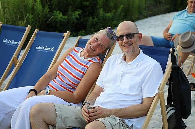 Die Diashow zeigt Eindrücke vom Salsa-Abend am Eckert Beach. Zu sehen sind tanzende Paare, Besucherinnen und Besucher im Publikum sowie die stimmungsvolle Atmosphäre der Veranstaltung am Abend.