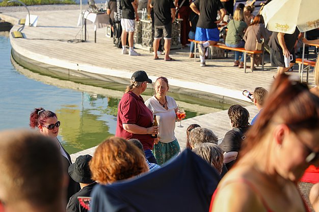 Die Bilder zeigen Eindrücke der Rock-Nacht am Eckert Beach. Zu sehen sind die Live-Auftritte der Bands Rusty Road Runners und ACBarbingCity´25, zahlreiche Besucherinnen und Besucher vor der Bühne sowie die sommerliche Atmosphäre am Strand. In beiden Bands stehen auch Dozenten der Eckert Schulen auf der Bühne. Die Aufnahmen zeigen Musiker, Publikum und die stimmungsvolle Beleuchtung während des Open-Air-Konzerts.
