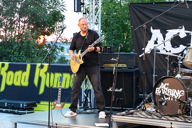 Die Bilder zeigen Eindrücke der Rock-Nacht am Eckert Beach. Zu sehen sind die Live-Auftritte der Bands Rusty Road Runners und ACBarbingCity´25, zahlreiche Besucherinnen und Besucher vor der Bühne sowie die sommerliche Atmosphäre am Strand. In beiden Bands stehen auch Dozenten der Eckert Schulen auf der Bühne. Die Aufnahmen zeigen Musiker, Publikum und die stimmungsvolle Beleuchtung während des Open-Air-Konzerts.