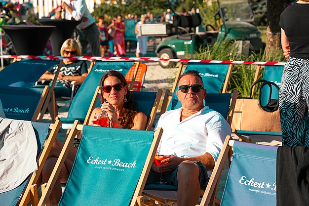 Gäste genießen gemeinsam die ausgelassene Atmosphäre bei der 80er-Jahre-Party am Eckert Beach.