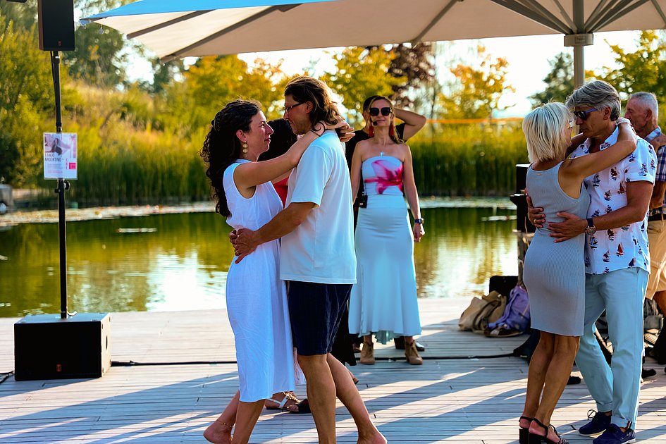 Die Bilder zeigen Impressionen der Tango Nacht am Eckert Beach mit Tanzpaaren, Schnupperkurs, Live-DJ, sommerlicher Atmosphäre und zahlreichen Gästen, die den Abschluss der Summer-Vibes-Reihe gemeinsam genießen.