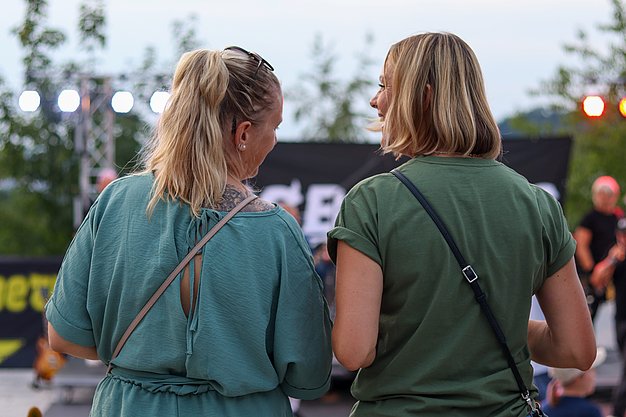 Die Bilder zeigen Eindrücke der Rock-Nacht am Eckert Beach. Zu sehen sind die Live-Auftritte der Bands Rusty Road Runners und ACBarbingCity´25, zahlreiche Besucherinnen und Besucher vor der Bühne sowie die sommerliche Atmosphäre am Strand. In beiden Bands stehen auch Dozenten der Eckert Schulen auf der Bühne. Die Aufnahmen zeigen Musiker, Publikum und die stimmungsvolle Beleuchtung während des Open-Air-Konzerts.