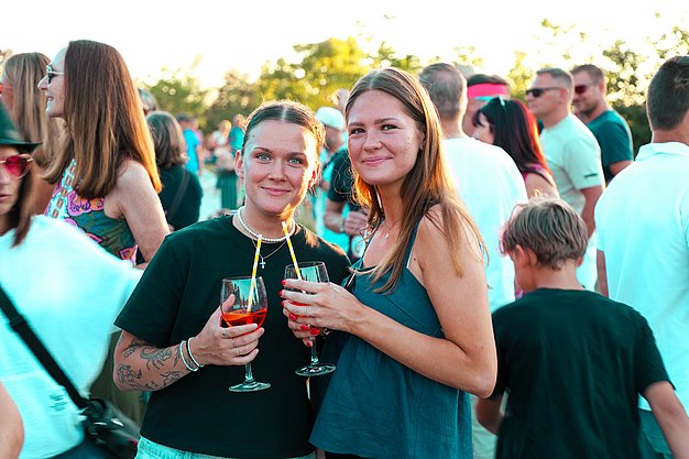 Gäste genießen gemeinsam die ausgelassene Atmosphäre bei der 80er-Jahre-Party am Eckert Beach.