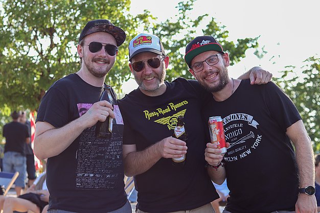 Die Bilder zeigen Eindrücke der Rock-Nacht am Eckert Beach. Zu sehen sind die Live-Auftritte der Bands Rusty Road Runners und ACBarbingCity´25, zahlreiche Besucherinnen und Besucher vor der Bühne sowie die sommerliche Atmosphäre am Strand. In beiden Bands stehen auch Dozenten der Eckert Schulen auf der Bühne. Die Aufnahmen zeigen Musiker, Publikum und die stimmungsvolle Beleuchtung während des Open-Air-Konzerts.