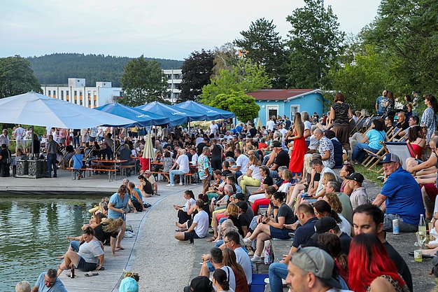 Die Bilder zeigen Eindrücke der Rock-Nacht am Eckert Beach. Zu sehen sind die Live-Auftritte der Bands Rusty Road Runners und ACBarbingCity´25, zahlreiche Besucherinnen und Besucher vor der Bühne sowie die sommerliche Atmosphäre am Strand. In beiden Bands stehen auch Dozenten der Eckert Schulen auf der Bühne. Die Aufnahmen zeigen Musiker, Publikum und die stimmungsvolle Beleuchtung während des Open-Air-Konzerts.