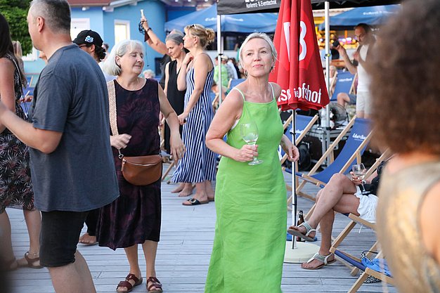 Die Diashow zeigt Eindrücke vom Salsa-Abend am Eckert Beach. Zu sehen sind tanzende Paare, Besucherinnen und Besucher im Publikum sowie die stimmungsvolle Atmosphäre der Veranstaltung am Abend.
