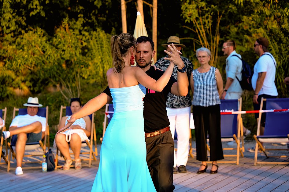 Die Bilder zeigen Impressionen der Tango Nacht am Eckert Beach mit Tanzpaaren, Schnupperkurs, Live-DJ, sommerlicher Atmosphäre und zahlreichen Gästen, die den Abschluss der Summer-Vibes-Reihe gemeinsam genießen.