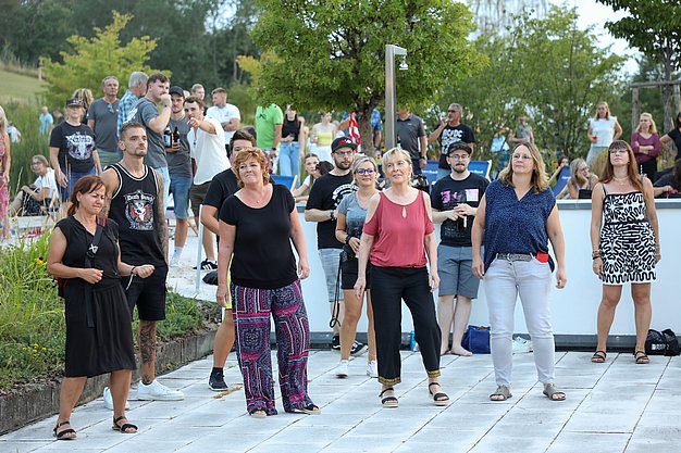 Die Bilder zeigen Eindrücke der Rock-Nacht am Eckert Beach. Zu sehen sind die Live-Auftritte der Bands Rusty Road Runners und ACBarbingCity´25, zahlreiche Besucherinnen und Besucher vor der Bühne sowie die sommerliche Atmosphäre am Strand. In beiden Bands stehen auch Dozenten der Eckert Schulen auf der Bühne. Die Aufnahmen zeigen Musiker, Publikum und die stimmungsvolle Beleuchtung während des Open-Air-Konzerts.