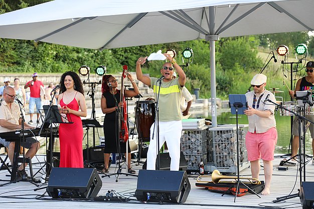 Die Diashow zeigt Eindrücke vom Salsa-Abend am Eckert Beach. Zu sehen sind tanzende Paare, Besucherinnen und Besucher im Publikum sowie die stimmungsvolle Atmosphäre der Veranstaltung am Abend.