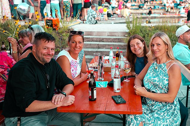 Gäste genießen gemeinsam die ausgelassene Atmosphäre bei der 80er-Jahre-Party am Eckert Beach.
