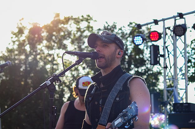 Die Bilder zeigen Eindrücke der Rock-Nacht am Eckert Beach. Zu sehen sind die Live-Auftritte der Bands Rusty Road Runners und ACBarbingCity´25, zahlreiche Besucherinnen und Besucher vor der Bühne sowie die sommerliche Atmosphäre am Strand. In beiden Bands stehen auch Dozenten der Eckert Schulen auf der Bühne. Die Aufnahmen zeigen Musiker, Publikum und die stimmungsvolle Beleuchtung während des Open-Air-Konzerts.